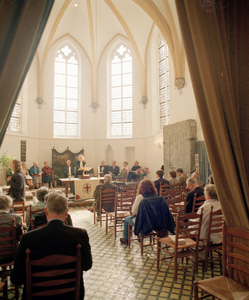 822501 Afbeelding van de voorgangster, bezoekers en het kerkkoor tijdens een kerkdienst van de Waalse Hervormde ...